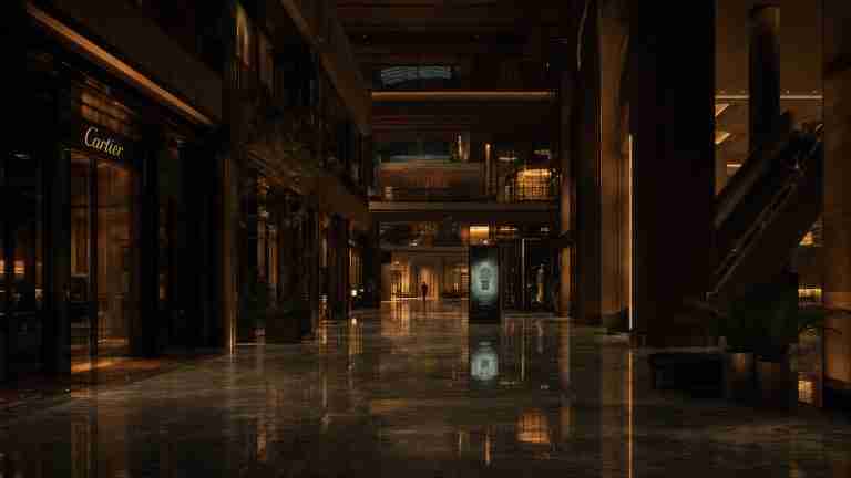 Empty shopping centre concourse after hours, illuminated by digital storefront displays the idle-hours media surface in Venue Intelligence